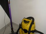 a yellow vacuum and a purple vacuum cleaner on the floor