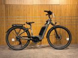 le vélo électrique est garé devant un mur en bois