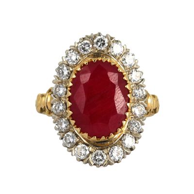 un gros plan d'une bague en pierre rouge et diamants sur fond blanc