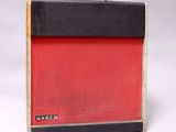 un ampli de guitare rouge et noir posé sur une surface blanche