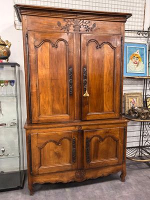 une grande armoire en bois avec une porte vitrée dans une pièce