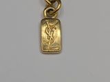 a close up of a gold necklace on a white surface