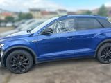 the blue volkswagen suv is parked in a parking lot with other cars