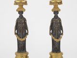 paire de bougeoirs anciens en laiton ornés de figurines sur des socles