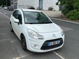 a small white car parked on the side of the road