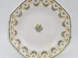 a close up of a plate on a stand on a white surface
