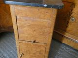 une armoire en bois avec un plateau en marbre, placée dans un coin