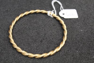 a close up of a rope bracelet with a tag on it