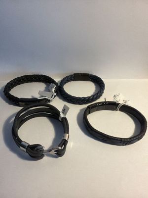 three black leather bracelets with silver clasps on a white surface