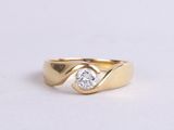 a close up of a gold ring with a diamond in the center