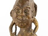 bronze statue of a woman with two hands on her head