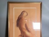 painting of a nude woman in a gold frame on a blue wall