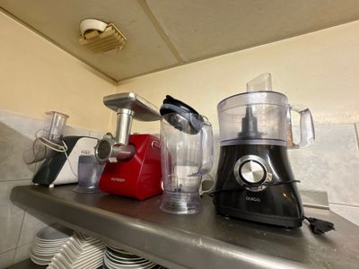 de nombreux mixeurs différents posés sur le plan de travail d'une cuisine