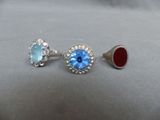 two pairs of rings with blue topaz and red topaz stones