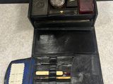 un étui en cuir noir contenant un stylo, des crayons et d'autres objets