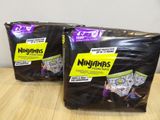 two packages of nigans diapers sitting on top of a wooden table