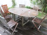 a wooden table and four chairs on a deck