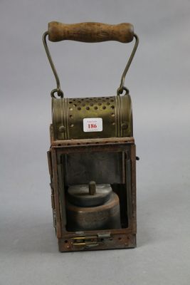 a small metal lantern with a wooden handle on a table