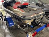 un bateau sur une remorque dans un garage, avec une voiture en arrière-plan