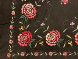 embroidered fabric with flowers and leaves on a black background