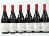 six bouteilles de vin rouge sont alignées sur une surface blanche