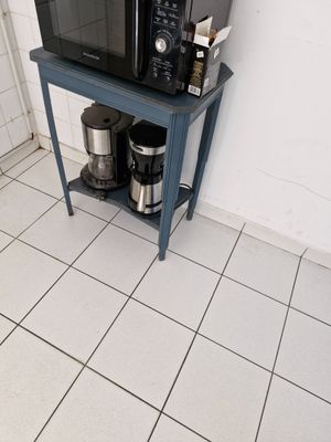 un micro-ondes posé sur une petite table dans la cuisine