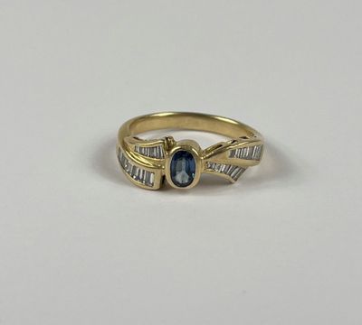 une bague en or jaune sertie d'un saphir bleu et de saphirs taille baguette