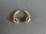 a close up of a gold ring with spikes on it