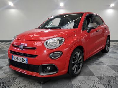 a red fiat car is parked on a checkered floor