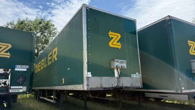 deux semi-remorques garées l'une à côté de l'autre dans un champ