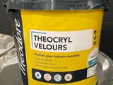 a bucket of yellow paint sitting on top of a table