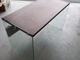 une table en verre avec un plateau en bois posée sur le trottoir