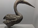 statue d'un pélican posé sur une surface blanche dans une pièce blanche