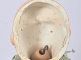 a vase with a bird inside of it on a table