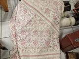 a blanket that is laying on the floor next to a suitcase