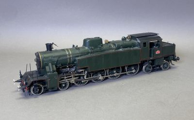 un petit train sur une surface blanche, avec un fond gris