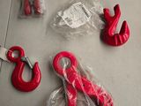 quelques crochets rouges et une paire de ciseaux posés sur une table