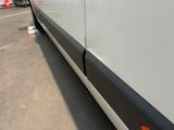 a white van parked in a parking lot with other vehicles in the background