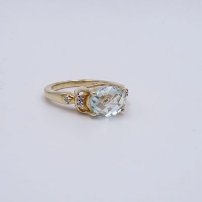 Gros plan sur une bague en or ornée d'une topaze bleue