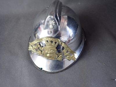 a silver fireman ' s helmet with a gold emblem on it
