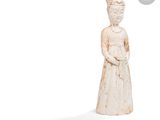 statue d'une femme vêtue d'une robe blanche et coiffée d'un chapeau