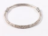 a close up of a silver bang bracelet with a flower design on it