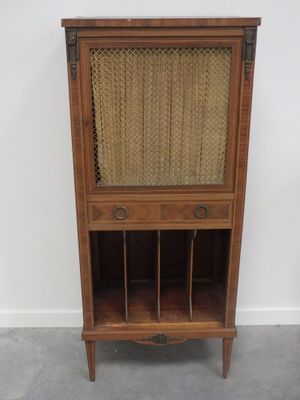 une vieille armoire en bois avec un plateau en osier et une porte vitrée