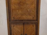 an old wooden cabinet with two doors and a drawer on top of it