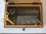 a small wooden box with a clock inside of it