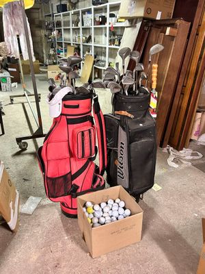 two bags of golf balls and a bag of golf clubs on the floor