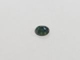 a green tourmaline stone on a white surface