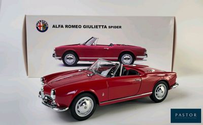 a red model of a classic car in front of a box