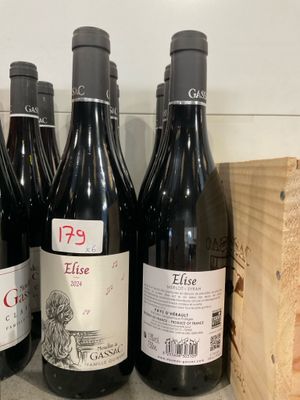 plusieurs bouteilles de vin rouge sont alignées sur une étagère