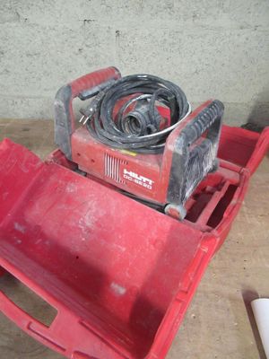une boîte à outils rouge contenant un tuyau, posée sur une table